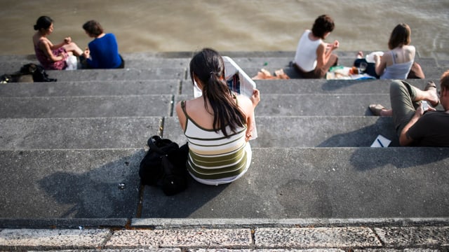 Junge Menschen sitzen auf einer Treppen. Man sieht sie von hinten. Junge Menschen sitzen auf einer Treppen. Man sieht sie von hinten.