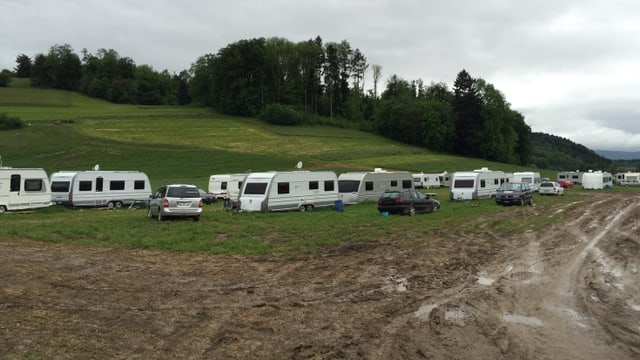 Fuhrpark mit rund 20 Autos und Anhängern von Fahrenden auf einem Feld. Fuhrpark mit rund 20 Autos und Anhängern von Fahrenden auf einem Feld.