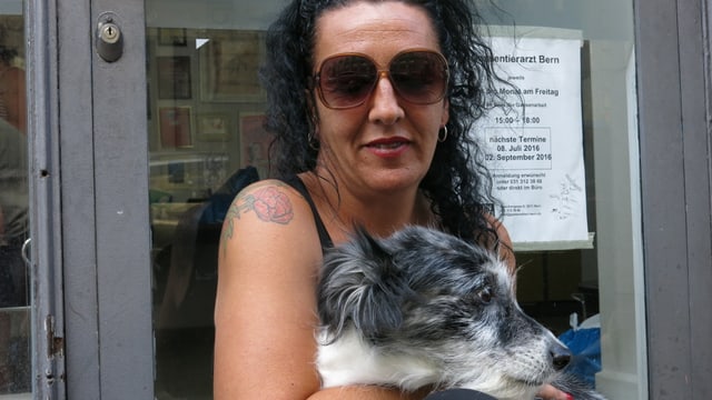 Porträt von Isabel Calvo, auf dem Schoss hat sie einen grau-weissen Hund. Porträt von Isabel Calvo, auf dem Schoss hat sie einen grau-weissen Hund.