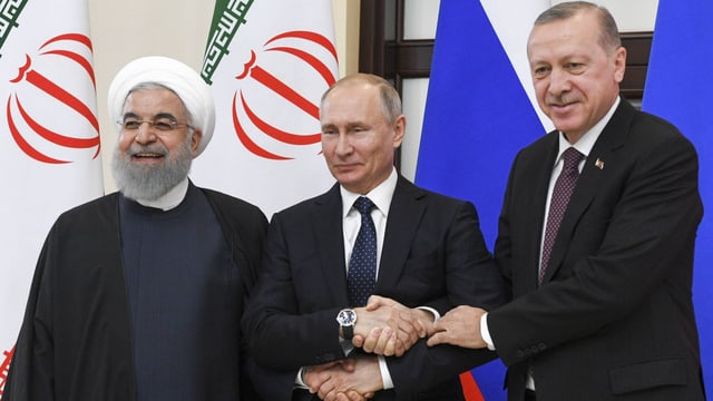 Rohani, Putin und Erdogan geben sich die Hände und lächeln in die Kamera. Rohani, Putin und Erdogan geben sich die Hände und lächeln in die Kamera.