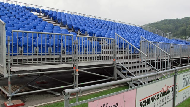 Gerüst-Tribüne mit blauen Klappstühlen aus Plastik Gerüst-Tribüne mit blauen Klappstühlen aus Plastik