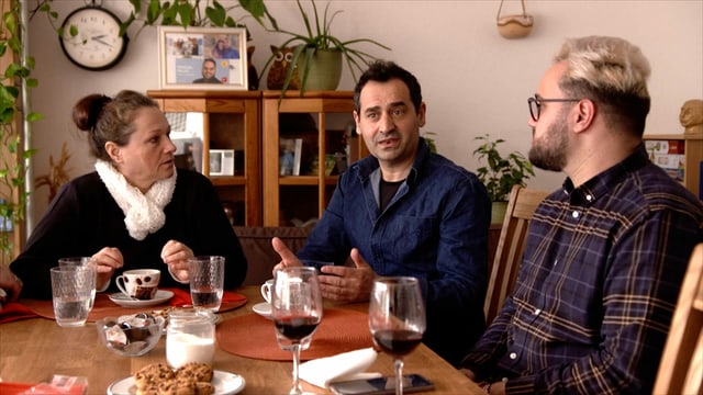 ein älterer Mann und eine Frau sitzen mit ihrem erwachsenen Sohn am Tisch ein älterer Mann und eine Frau sitzen mit ihrem erwachsenen Sohn am Tisch