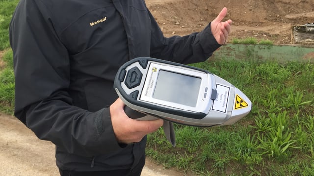 Mann hält ein Gerät in der Hand, das wie ein Scanner aussieht Mann hält ein Gerät in der Hand, das wie ein Scanner aussieht