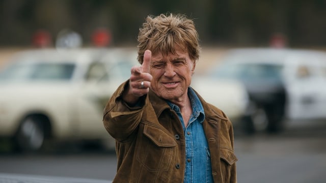 Robert Redford ahmt mit seiner Hand eine Pistole nach. Robert Redford ahmt mit seiner Hand eine Pistole nach.