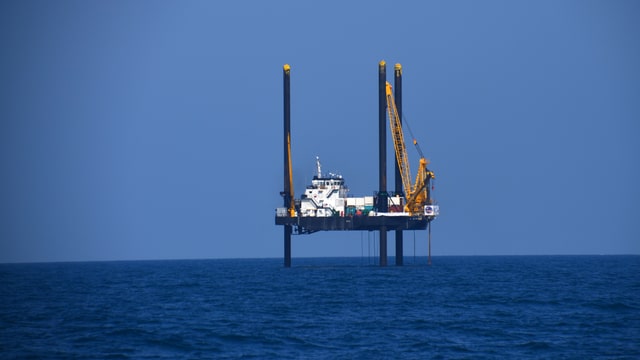 Ein Schiff ist mit drei grossen Pfeilern über dem Meeresspiegel aufgehängt. Ein Schiff ist mit drei grossen Pfeilern über dem Meeresspiegel aufgehängt.