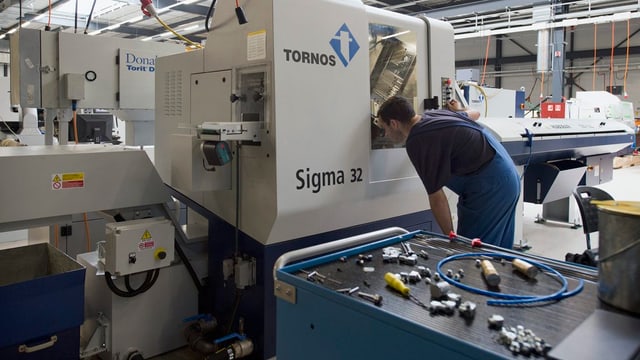 Mitarbeiter kontrolliert eine Maschine. Mitarbeiter kontrolliert eine Maschine.
