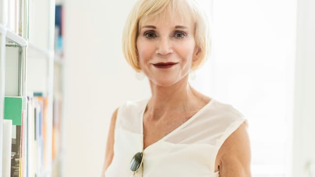 eine Frau steht vor einem Bücherregal eine Frau steht vor einem Bücherregal