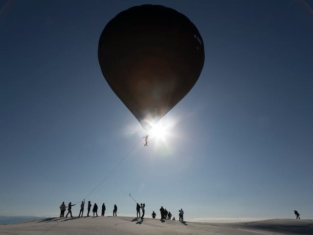 Ein Mann, mithilfe eines riesen Ballons schwebt. Ein Mann, mithilfe eines riesen Ballons schwebt.