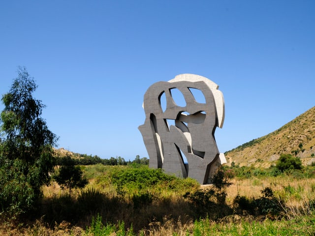 Eine Skulptur in einer Graslandschaft, bestehend aus zwei unterschiedlich gefärbten Stein-Formen. Eine Skulptur in einer Graslandschaft, bestehend aus zwei unterschiedlich gefärbten Stein-Formen.
