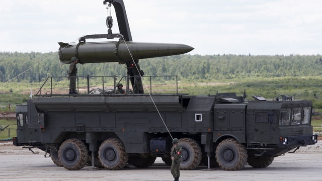 Soldaten laten eine Rakete auf einen Lastwagen Soldaten laten eine Rakete auf einen Lastwagen