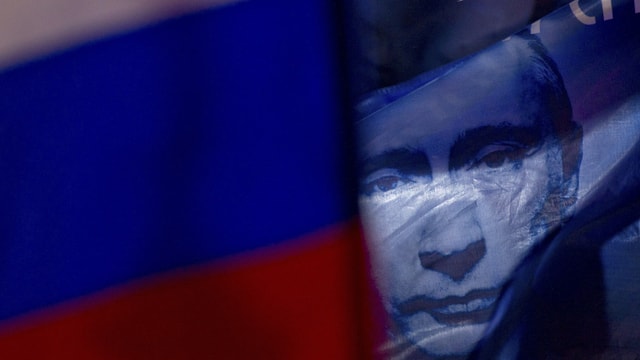 Putin-Bild hinter einer Russland-Flagge Putin-Bild hinter einer Russland-Flagge