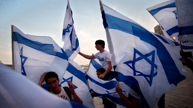 Ein paar junge Männer schwingen Israel-Fahnen. Ein paar junge Männer schwingen Israel-Fahnen.