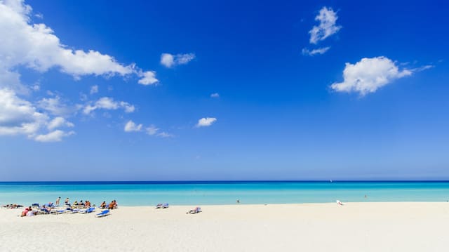Schneeweiser Strand mit einigen Badegästen und blauer Himmel. Schneeweiser Strand mit einigen Badegästen und blauer Himmel.