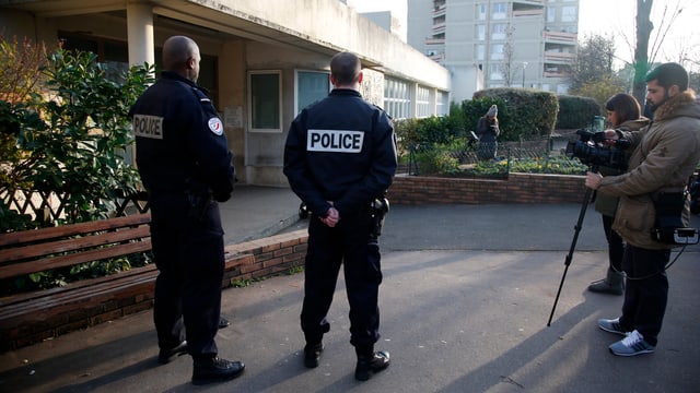 Polizisten und Journalisten vor einem Gebäude. Polizisten und Journalisten vor einem Gebäude.