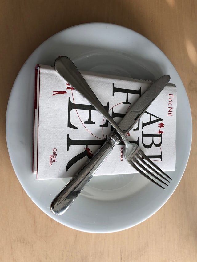 «Abifeier» von Eric Nil liegt auf einem weissen Teller. Messer und Gabel in 20-nach-8-Stellung darüber. «Abifeier» von Eric Nil liegt auf einem weissen Teller. Messer und Gabel in 20-nach-8-Stellung darüber.