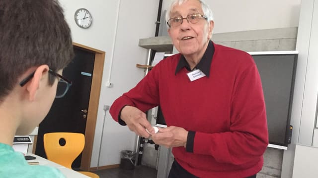 Älterer Mann erklärt einem Buben etwas Älterer Mann erklärt einem Buben etwas
