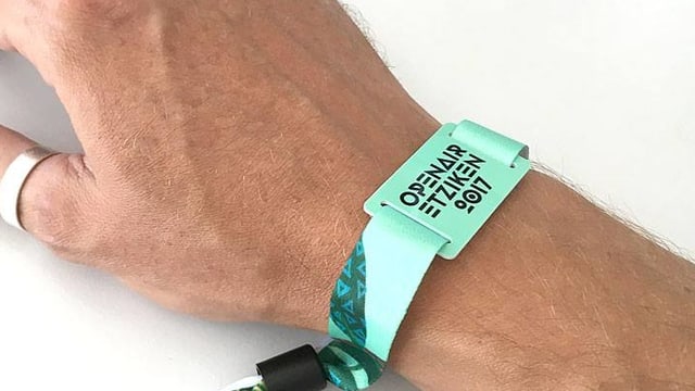 Hand mit Bändeli mit Aufschrift Openair Etziken 2017 Hand mit Bändeli mit Aufschrift Openair Etziken 2017