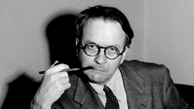 Schwarz-Weiss-Pèorträt von Chandler mit schwarzer Brille, er raucht eine Pfeife. Schwarz-Weiss-Pèorträt von Chandler mit schwarzer Brille, er raucht eine Pfeife.