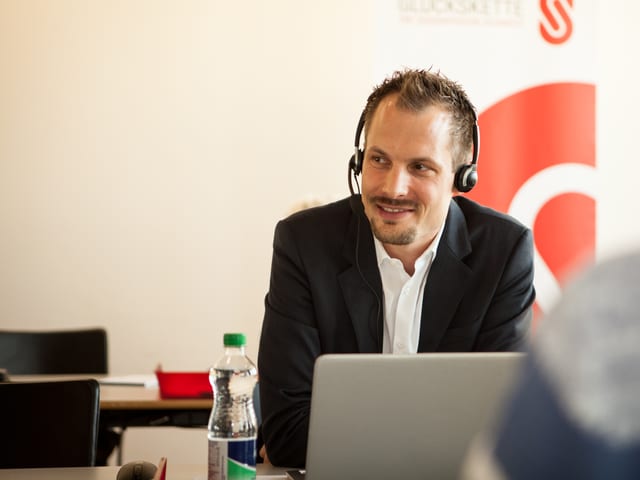 Mann mit Jacket am Telefon.