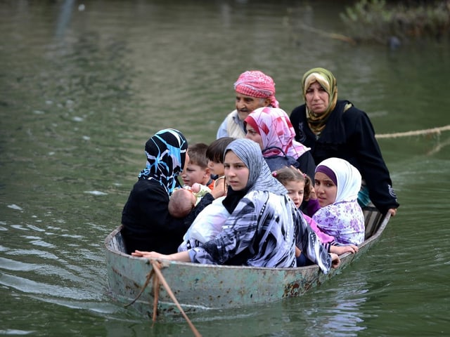 Frauen und Kinder gedrängt auf einem kleinen Boot.
