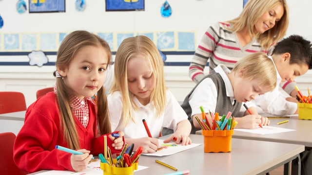 Kinder in der Schule mit einer Lehrerin. Kinder in der Schule mit einer Lehrerin.