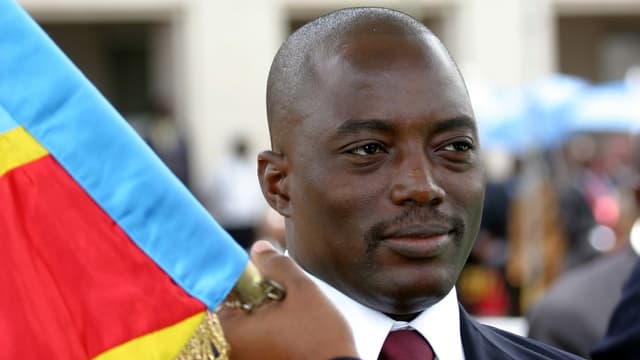 Kopfausnahme von Kabila mit einem Träger der kongolesischen Fahne. Kopfausnahme von Kabila mit einem Träger der kongolesischen Fahne.