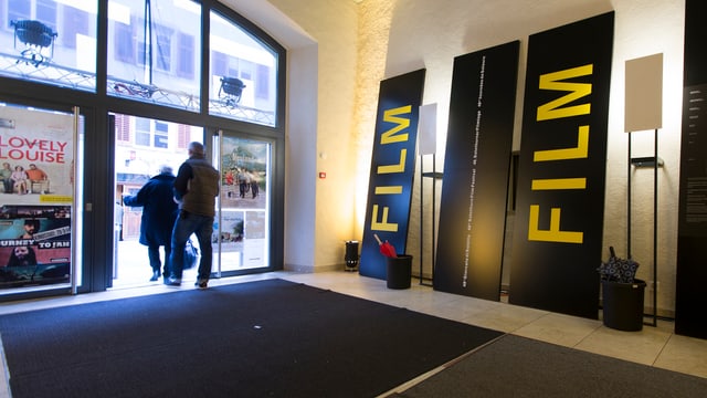 Kinofoyer mit zwei übergrossen Transparenten auf denen «Film» steht. Kinofoyer mit zwei übergrossen Transparenten auf denen «Film» steht.
