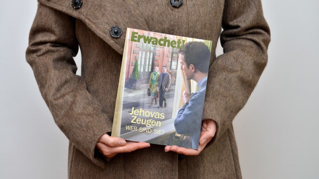Eine Frau hält ein Heft mit dem Titel "Erwachet!" in der Hand. Eine Frau hält ein Heft mit dem Titel "Erwachet!" in der Hand.