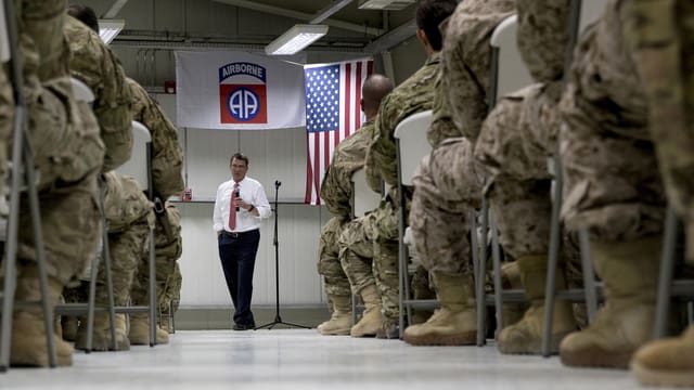 Soldaten sitzen in einer Halle auf Stühlen, vor ihnen spricht ein zivil gekleideter Mann. Soldaten sitzen in einer Halle auf Stühlen, vor ihnen spricht ein zivil gekleideter Mann.