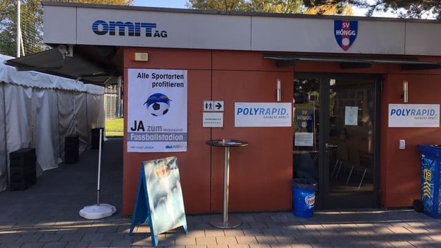 Ein Häuschen bei einer Sportanlage in Zürich-Höngg, an dem ein Plakat für das Stadion hängt. Ein Häuschen bei einer Sportanlage in Zürich-Höngg, an dem ein Plakat für das Stadion hängt.