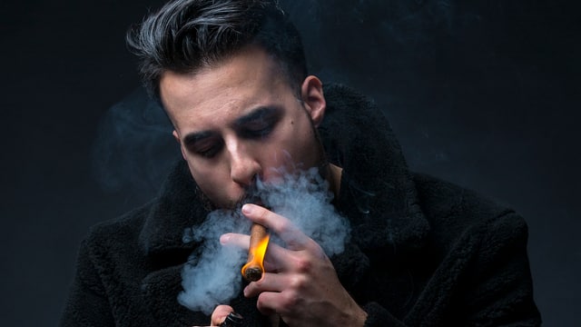 Der Rapper Don Fuego entzündet eine Zigarre Der Rapper Don Fuego entzündet eine Zigarre