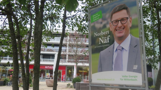 Wahlplakat von Norbert Näf mit Bäumen und Häuser im Hintergrund Wahlplakat von Norbert Näf mit Bäumen und Häuser im Hintergrund