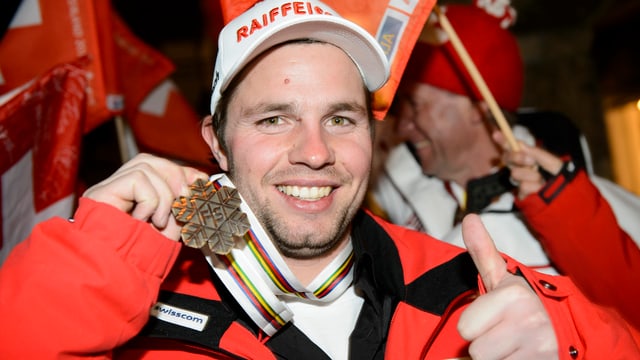 Beat Feuz posiert mit seiner Bronzemedaille, dazu streckt er seinen linken Daumen nach oben. Beat Feuz posiert mit seiner Bronzemedaille, dazu streckt er seinen linken Daumen nach oben.