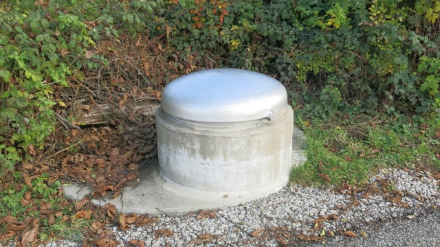 Gefasste Quelle. Rundes Betonelement mit Stahldeckel. Gefasste Quelle. Rundes Betonelement mit Stahldeckel.