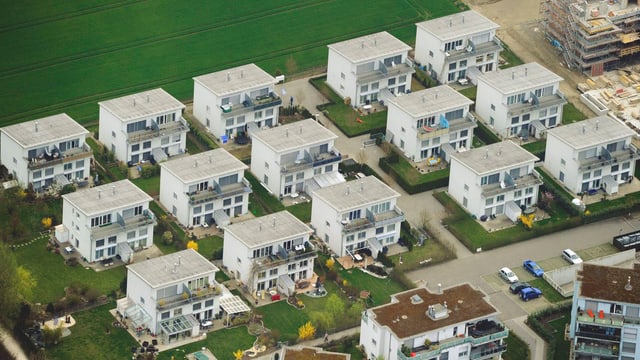 Eine Einfamilienhaus-Siedlung. Die weissen Häuser stehen dicht nebeneinander. Eine Einfamilienhaus-Siedlung. Die weissen Häuser stehen dicht nebeneinander.