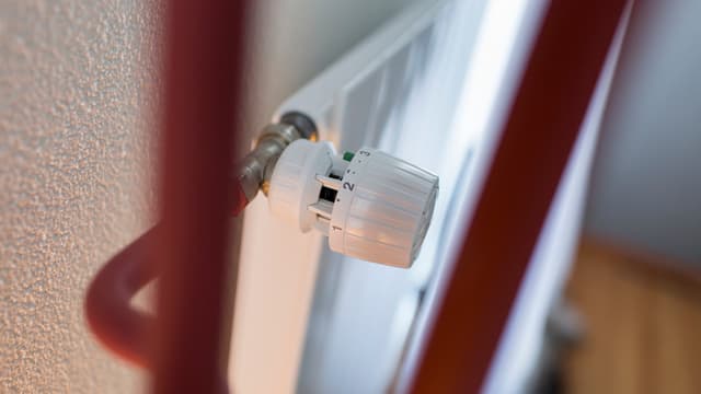 Rote Röhren an einem Heizkörper mit Regulier-Ventil. Rote Röhren an einem Heizkörper mit Regulier-Ventil.