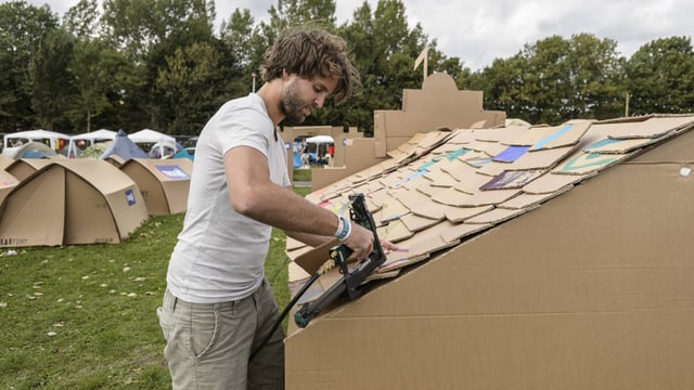 Ein Mann befestigt ein Kartent an einem Festival Ein Mann befestigt ein Kartent an einem Festival