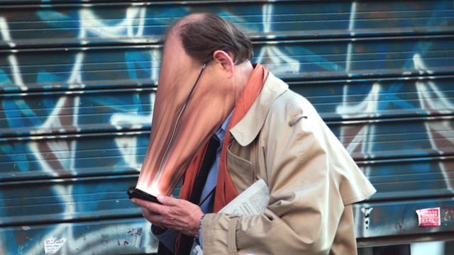 Ein Mann mit zum Smartphone hin verzerrtem Gesicht. Ein Mann mit zum Smartphone hin verzerrtem Gesicht.
