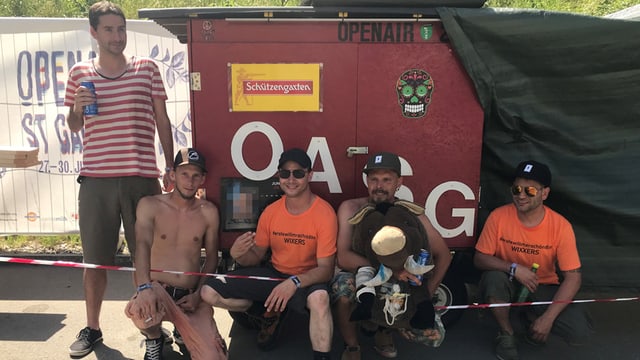 Männer im Schatten vor einem Container Männer im Schatten vor einem Container