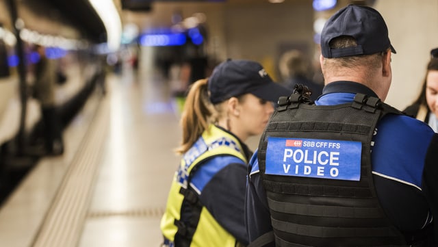 Zwei Polizisten neben einem Zug. Zwei Polizisten neben einem Zug.