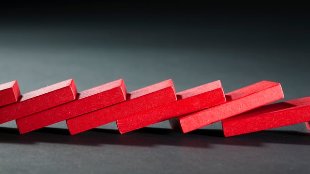 Reihe rote Dominosteine, die umgefallen ist. Reihe rote Dominosteine, die umgefallen ist.