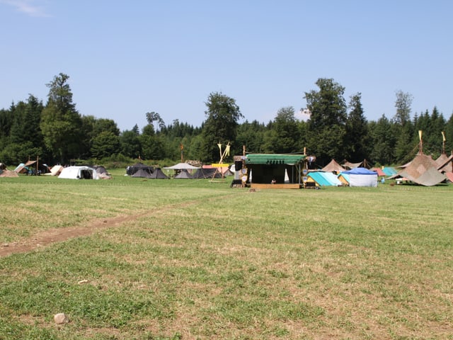 Blick über das Sommerlager der Pfadi Kanton Aarau. Im Hintergrund die schwarzen Zelte der deutschen Pfadi-Gäste aus Hannover.