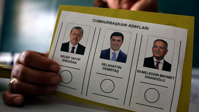 Eine Wahlkarte mit den Köpfen der drei Kandidaten.