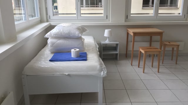 Eine sanierte Wohung mit Bett und Tisch Eine sanierte Wohung mit Bett und Tisch