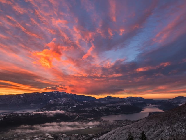 Landschaft bei Sonnenaufgang mit rotem Himmel.