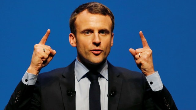 Emmanuel Macron mit zwei erhobenen Händen und Zeigefingern