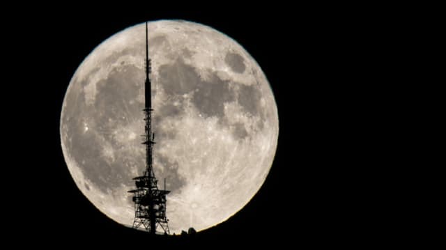Der Vollmond war hinter dem Sendemasten des Niederhorns zu sehen. Der Vollmond war hinter dem Sendemasten des Niederhorns zu sehen.