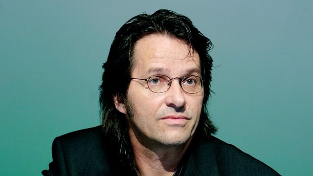 Ralf Rothmann in schwarzem Anzug, mit Brille. Ralf Rothmann in schwarzem Anzug, mit Brille.