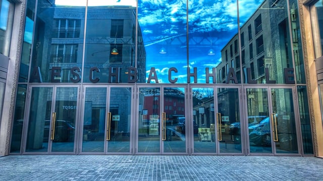 Eingang Aeschbachhalle mit spiegelnder Glasfront Eingang Aeschbachhalle mit spiegelnder Glasfront