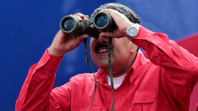 Maduro in rotem Hemd, schaut in ein Fernglas. Maduro in rotem Hemd, schaut in ein Fernglas.